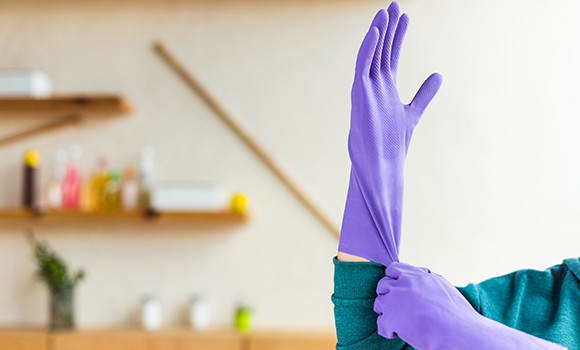 person puts on purple rubber gloves getting ready to clean a home in Ottawa